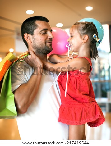 happy father with cute little daughter shopping in mall