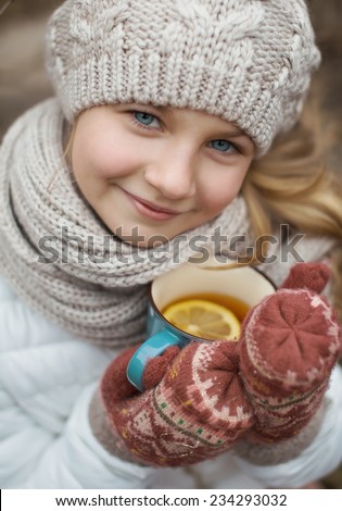 portrait of a cute girl with a cup of hot tea outdoors