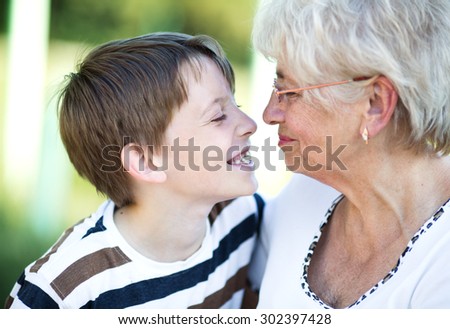 Closeup summer portrait of happy grandmother with grandson outdoors
