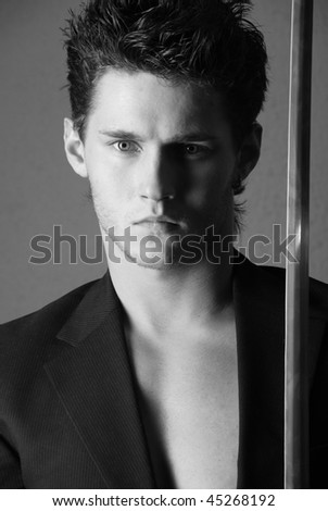 Young good-looking model in suite with a sword