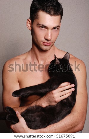 Muscled male model posing in studio with a cat