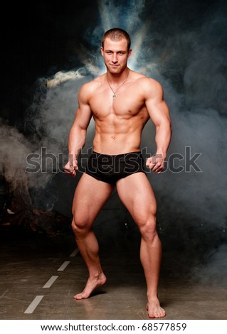 Muscled male model posing in studio with a smoke