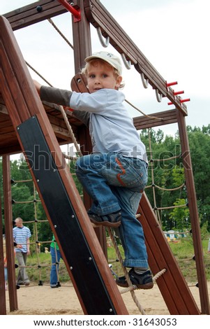 Child on a playground. Three years old boy playing at a playground.