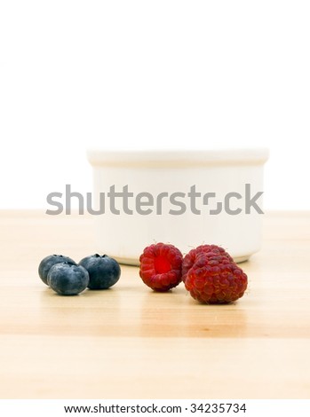 Raspberries and blue berries on a wooden table