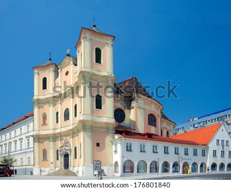 Bratislava, Slovakia - June 17 2013: Side view of Trinitarian Church or Trinity Church (full name Church of Saint John of Matha and Saint Felix of Valois, 1717) and the passers-by on the street.