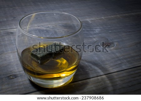 Glass of Bourbon with Whisky Stones on a Vintage Wood Farm Table