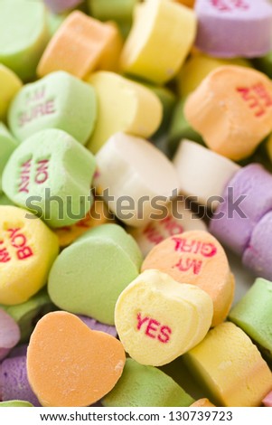 Pile of conversation heart candies on white background.