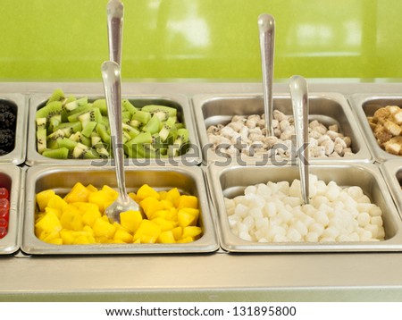 Frozen yogurt toppings bar. Yogurt toppings ranging from fresh fruits, nuts, fresh-cut candies, syrups and sprinkles.