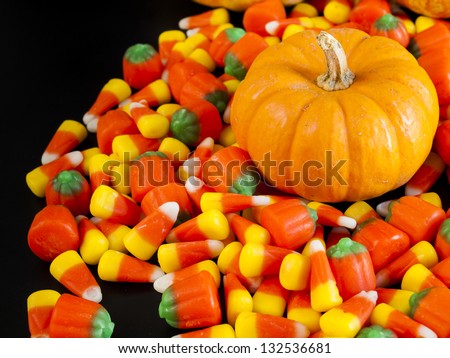 Halloween candy corn and pumpkin candies on black background.
