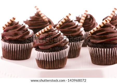 Small dark chocolate cupcakes at dessert bar.