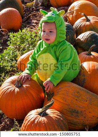 Toddler dressed up in cute costumes at the pumpkin patch.