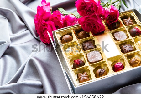 Gift box of assorted gourmet chocolate truffles on silver silk.