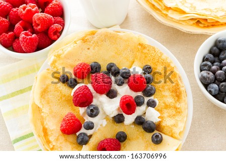Homemade crepes with fresh raspberries and blueberries.