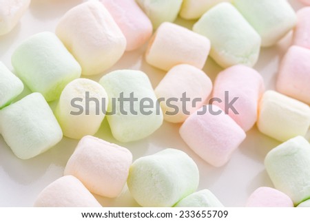Small round multicolor marshmallows on a white backgrouns.