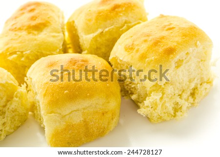 Freshly baked sourdough dinner rolls on a white background.