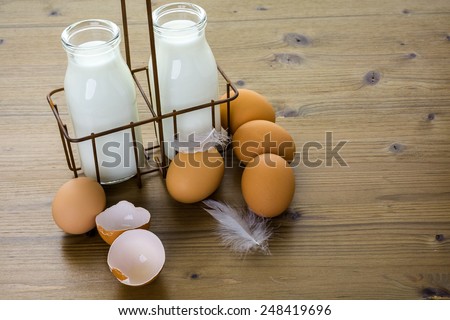 Fresh farm eggs and milk on wood table.
