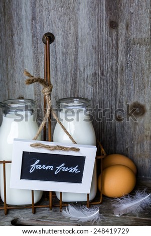 Fresh farm milk in glass jars and eggs on wood table