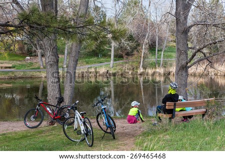 Denver, Colorado, USA-April 11, 2015. Family on bike ride in urban park on weekend.