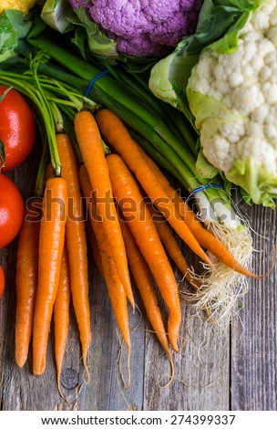 Fresh organic vegetable in season on old farm table.