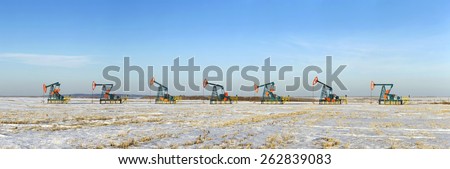 Oil pumping unit standing in a row on a snowy field