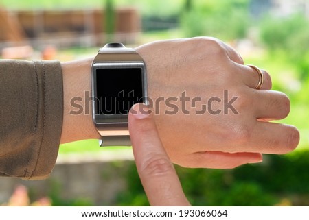 Close up of a smartwatch and an index finger as a concept of wearable technology