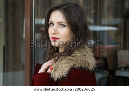 pretty girl in red coat and her expressive eyes outdoor