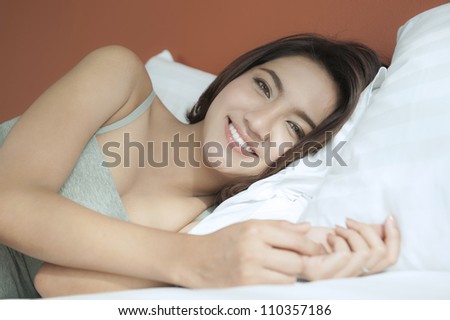 Happy Asian female just wake up in the morning on the bed