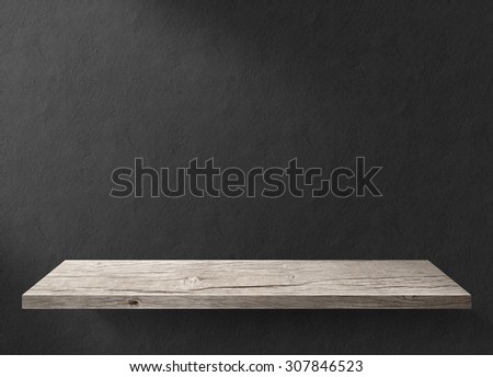 Wood table with black concrete wall