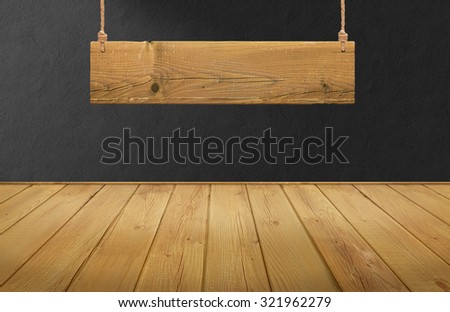 Wood table with hanging wooden sign on black concrete wall