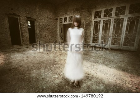 Horror movie scene with a girl dressed in white in a desolated house