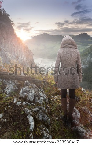 Woman on top of the mountain looking at the Christmas Star rising with the sunrise and announcing the birth of baby Jesus