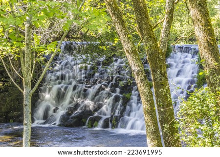 Beautiful waterfall in the trees from the river Arenteiro near the spa of Carballino in Orense, Spain.
