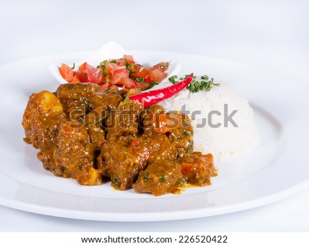 Beef curry and rice on a white plate on white background.