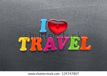 i love travel spelled out using colored fridge magnets