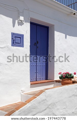 front side of typical spanish house with beautiful blue wooden door