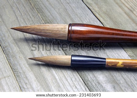 asian writing brushes on wooden background