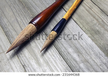 asian writing brushes on wooden background