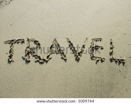 Word in the sand written by hand: travel. Useful for travel agencies or travel industry.