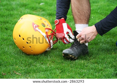American football player tie football boots.   American football concept  helmet