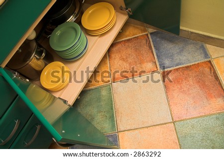 Open kitchen cupboard with dishes and plates. Colorful and lovely kitchen interior