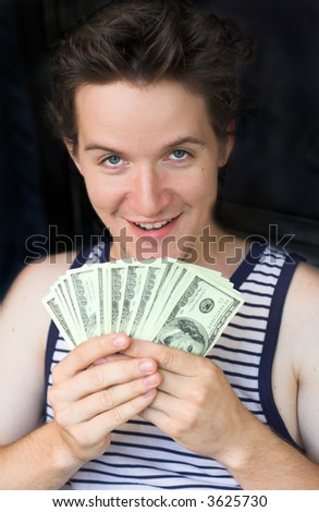 Young man counting american dollars. High profit and money concept. Focus on eyes