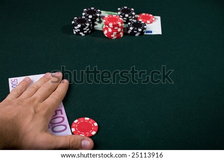 Casino player concept. pile of gambling chips and money on table. Focus on hand