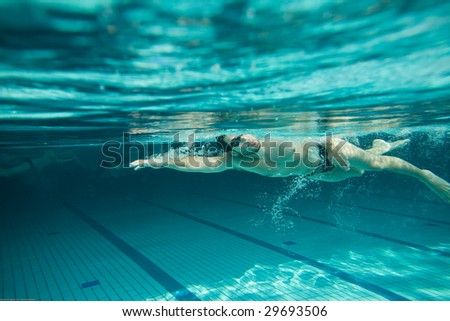 Swimmer swimming  in the pool. Underwater hi res photo.