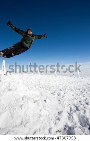 Young man enjoying winter at top of the mountain above the clouds