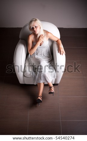 Sad woman sitting in sofa in empty room