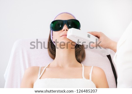Young woman receiving laser epilation on upper lip