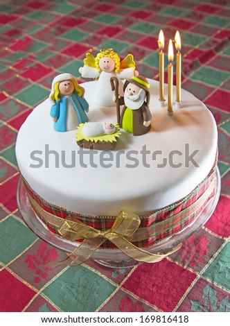 home made Christmas cake with sugar paste nativity and lit candles