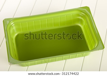 Green plastic mold on a white wooden background