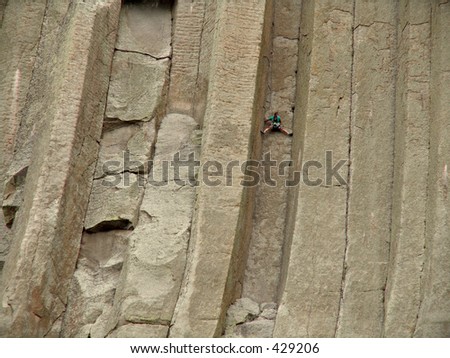 a climber scaling devils tower in wyoming