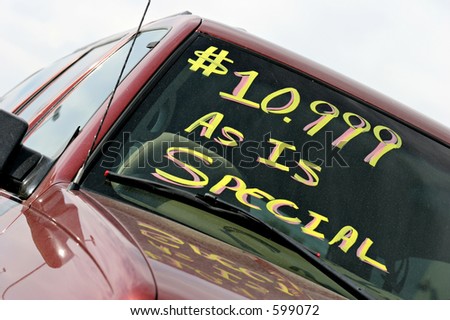 used car sales with special price written on windshield. note - dirty car and windshield.